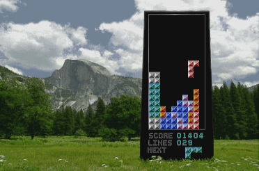 Screenshot from Tetris CD-i: a monolith with Tetris on it in a meadow, with a mountain in the background
