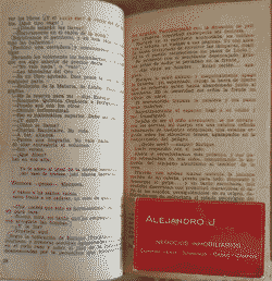 The book, wide open. A red business card in between the pages.